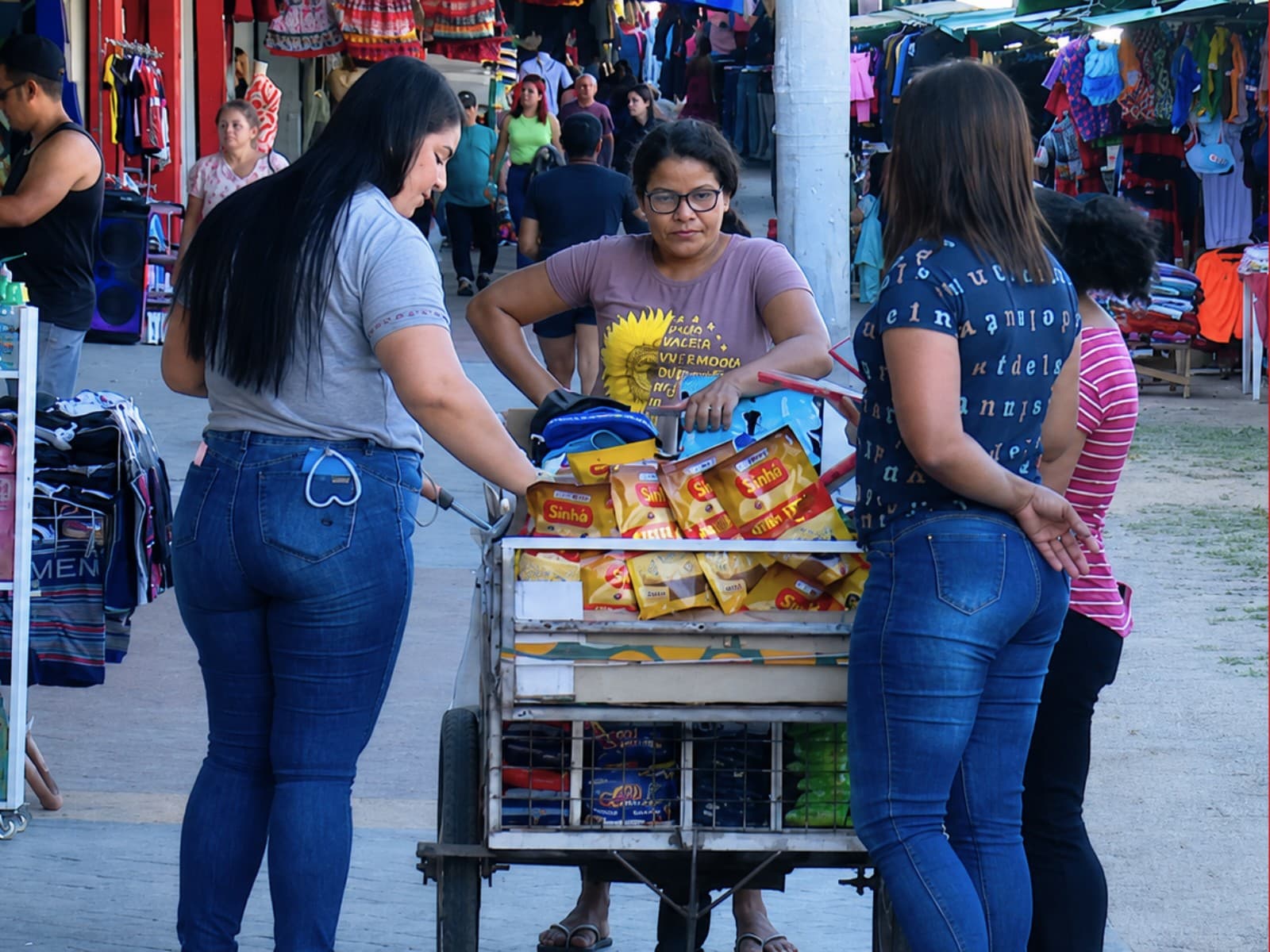 Mulher trabalha em computador enquanto cuida de criança em casa no Acre.