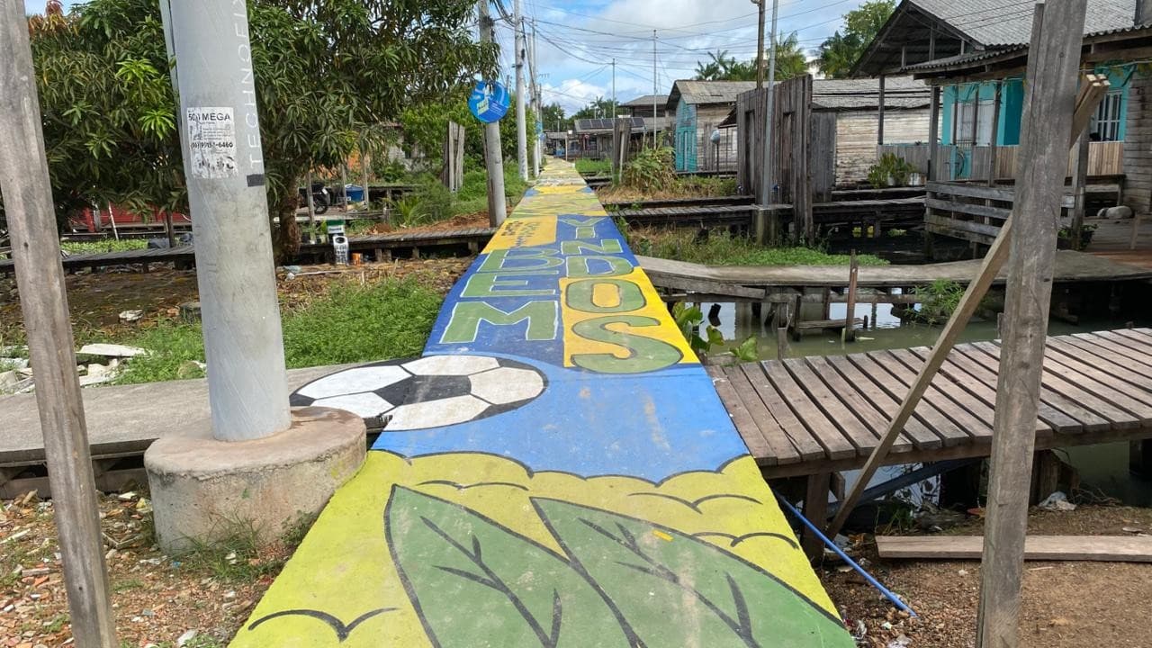 Moradores observam pintura em muro durante evento do Amapá em Campo no Zerão.