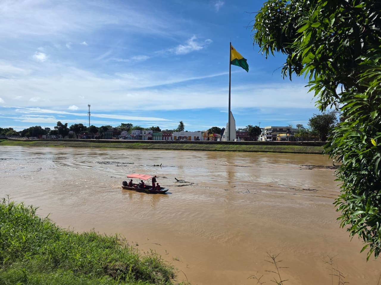 Grupo de pessoas boiando em bóias coloridas no meio do Rio Acre, com margens de terra ao fundo.