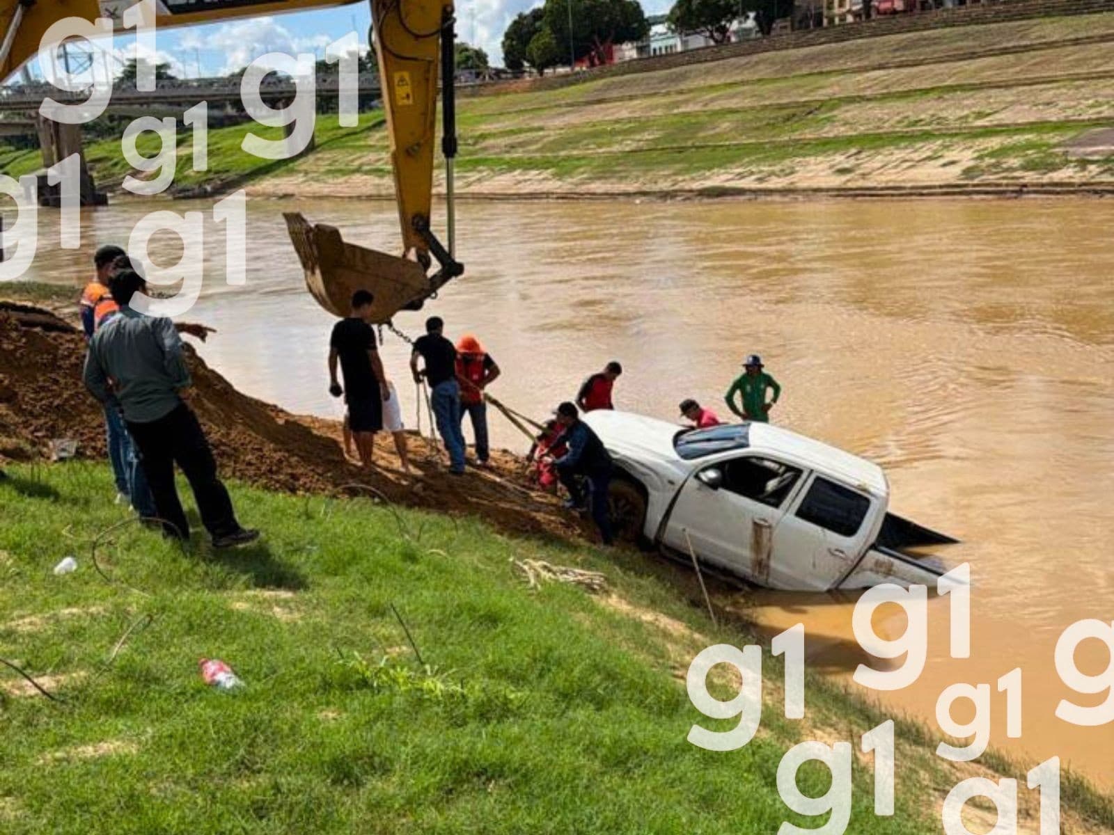 Retroescavadeira puxa caminhonete do lamaçal do leito do Rio Acre em Rio Branco.