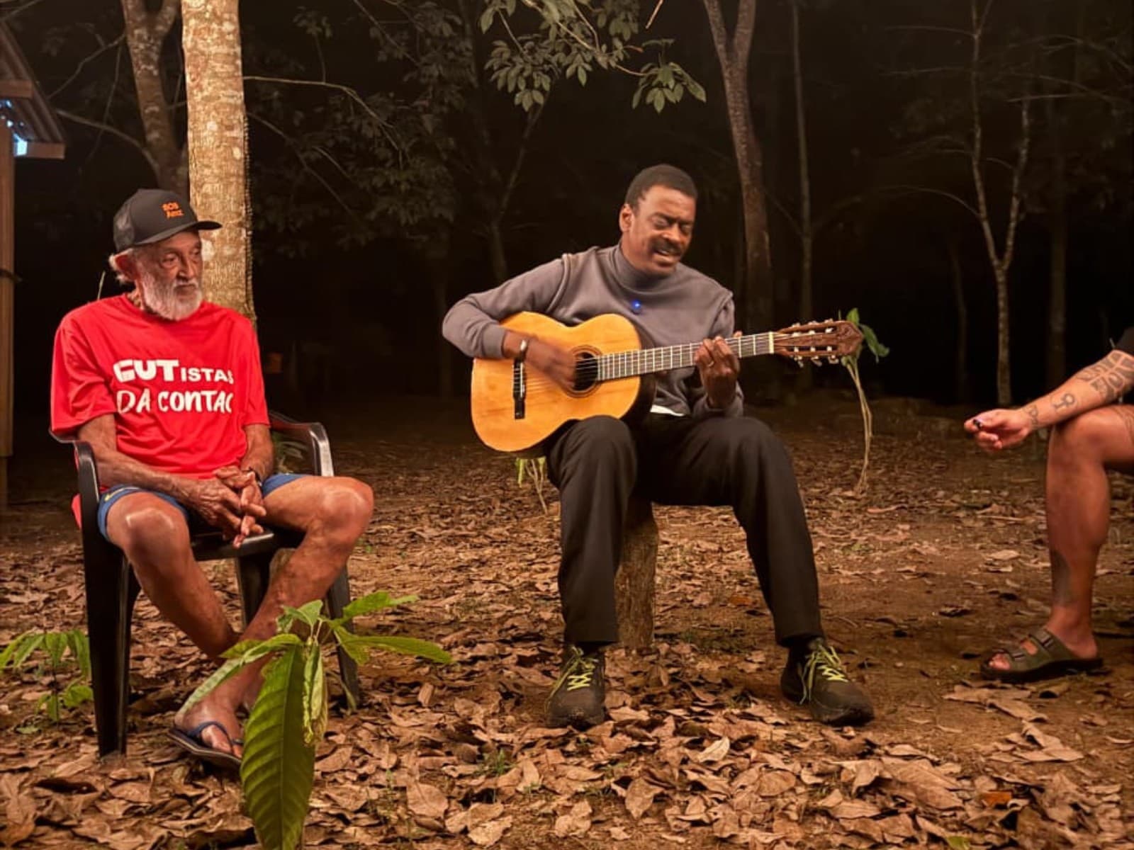 Seu Jorge e Raimundão conversam em varanda de madeira na Reserva Extrativista Chico Mendes.