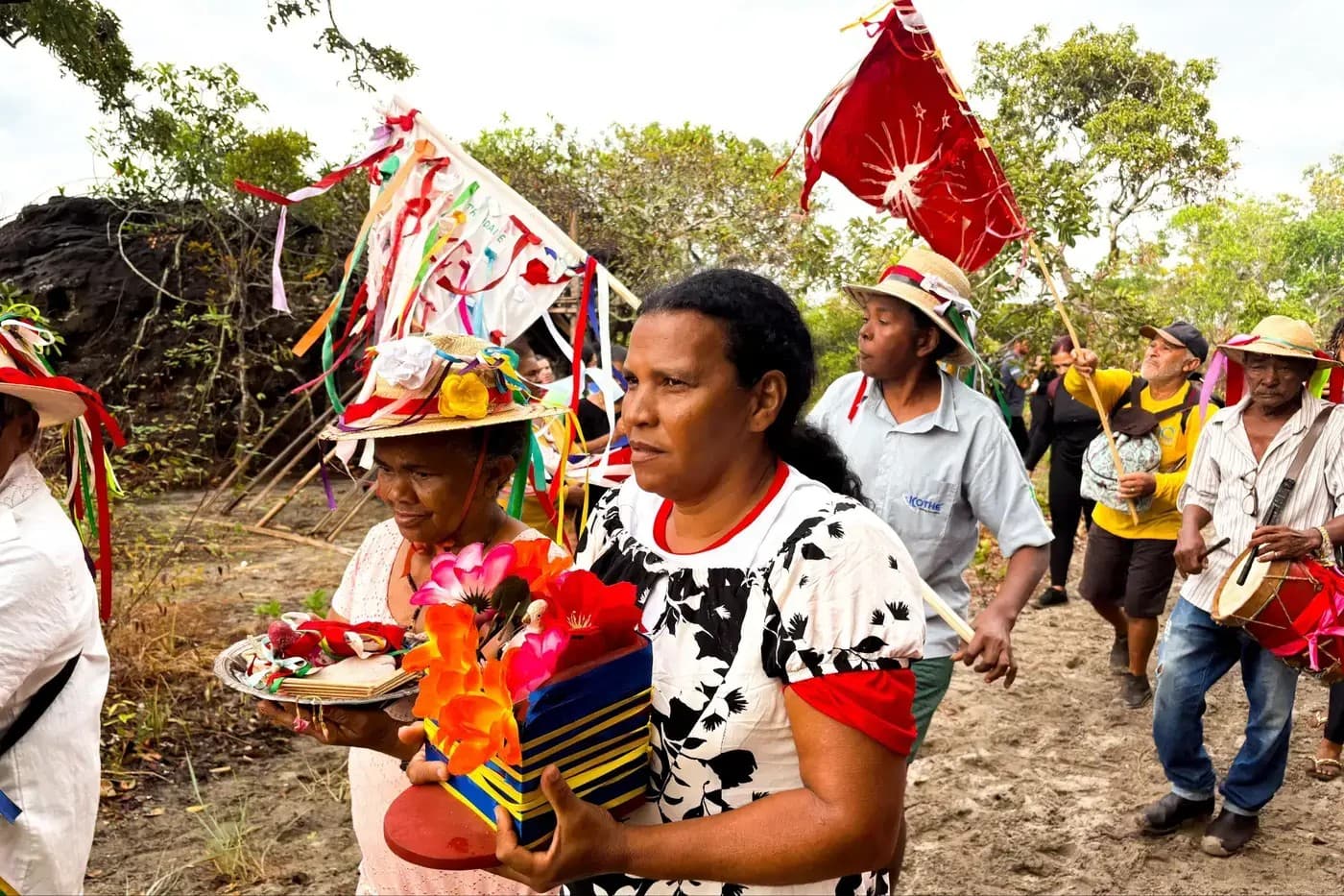 Romeiros caminham em trilha cercada de vegetação na Serra das Andorinhas