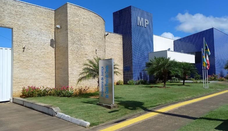 Professora lê edital em computador em sala de aula vazia em Nova União, Rondônia.