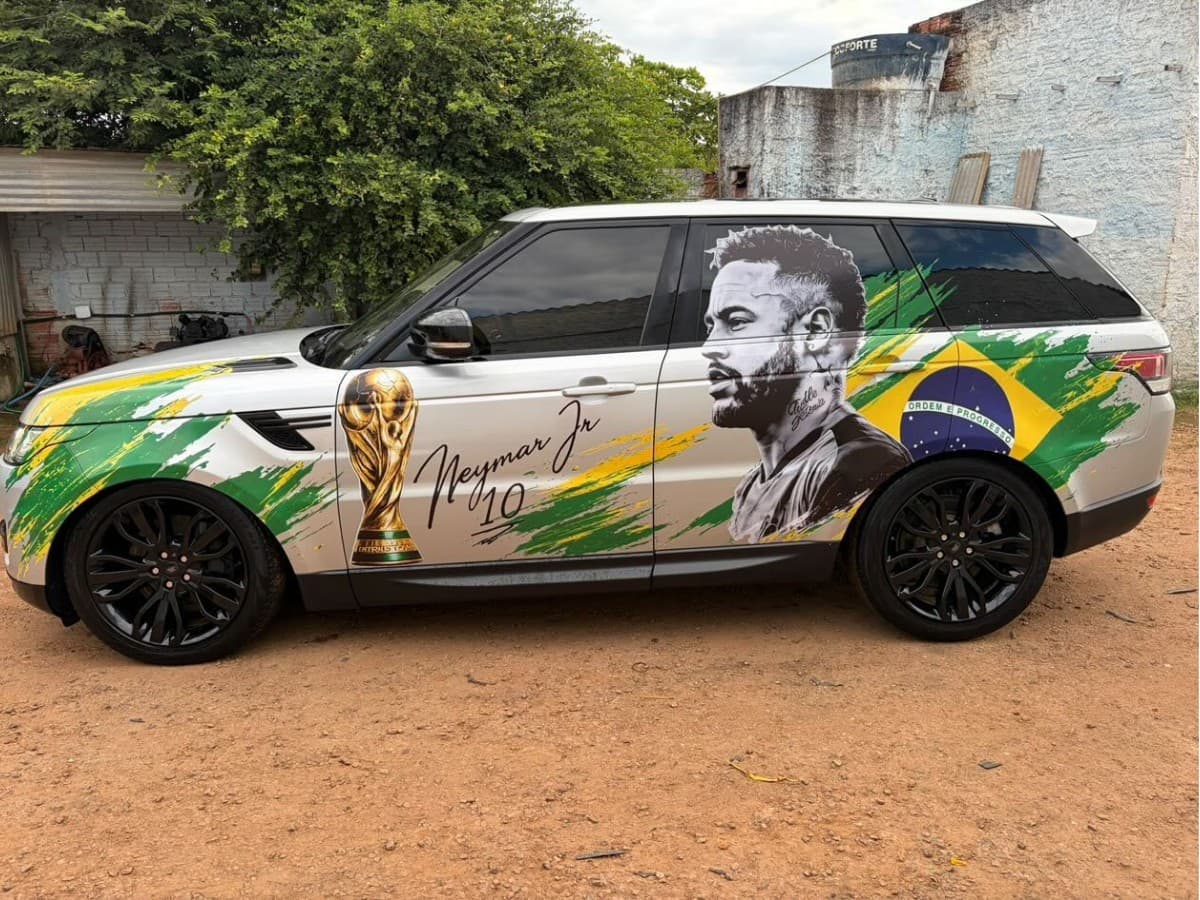 Carro SUV branco com adesivo gigante de Neymar na porta lateral estacionado em via pública de Porto Velho.