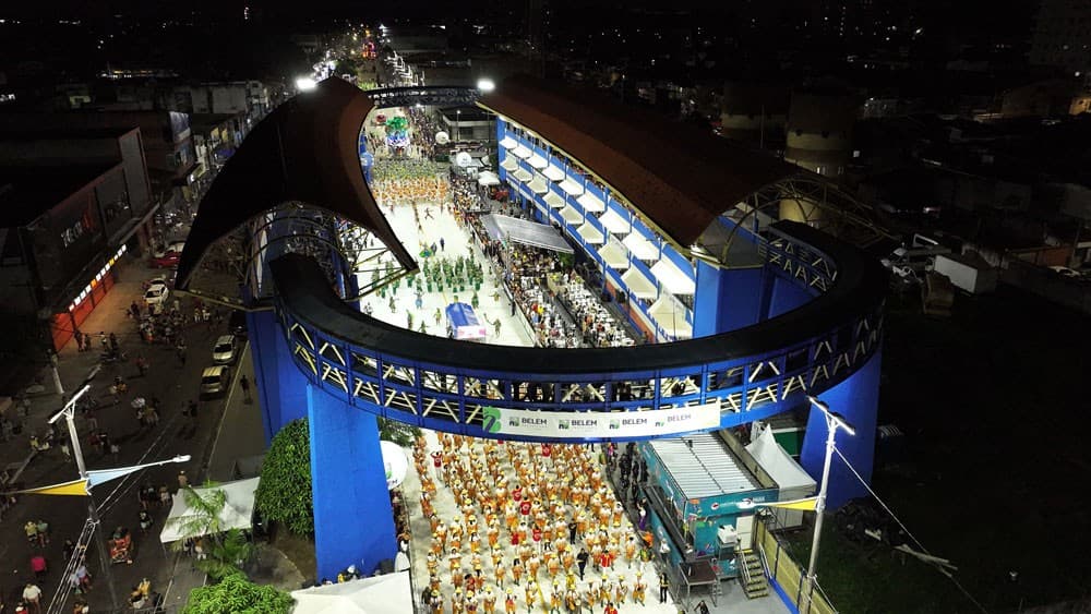 Pista da Aldeia Cabana iluminada durante desfile de escola de samba em noite de carnaval em Belém.