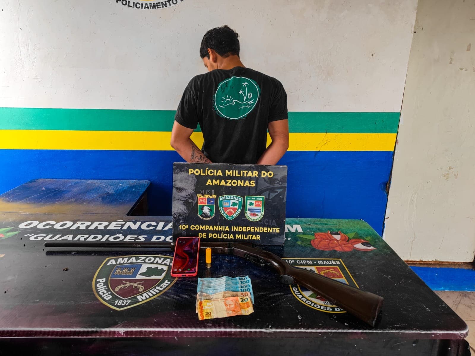 Viatura da Polícia Militar estacionada em rua residencial em Maués durante operação de prisão.