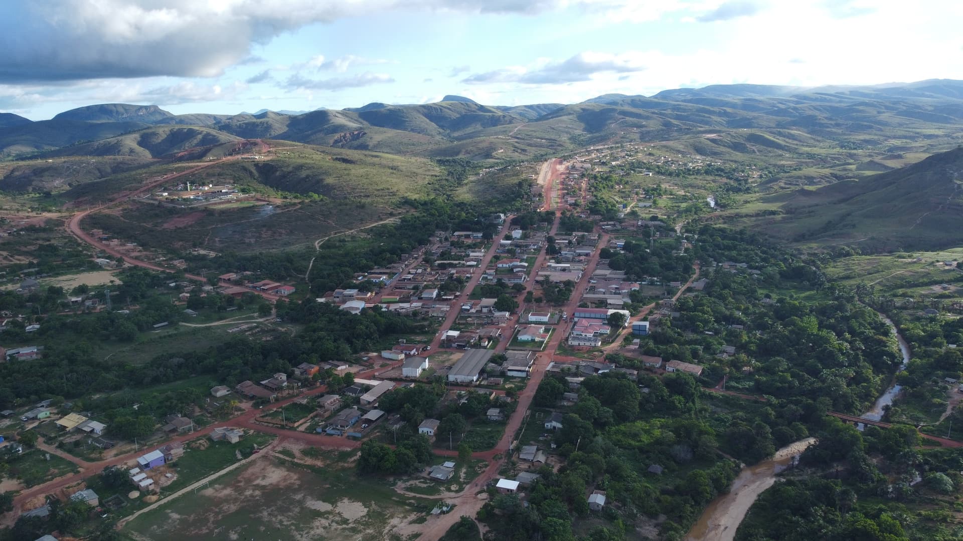 Vista da entrada da cidade de Uiramutã, em Roraima, com placa de turismo e estrada de terra.