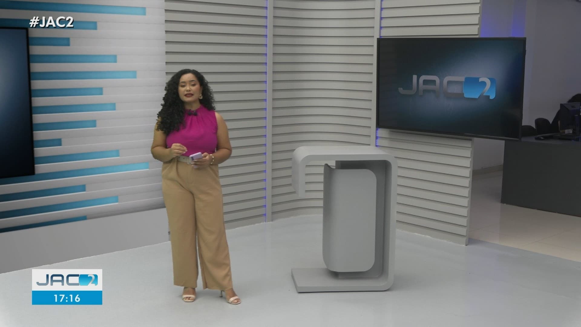 Câmeras de televisão focam no apresentador e no set de iluminação no estúdio da TV Acre.