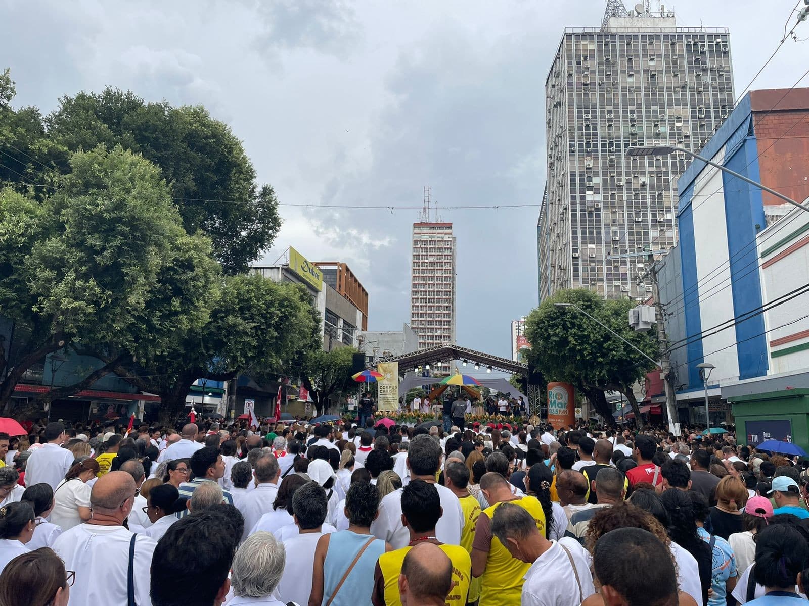 Voluntários espalham serragem colorida na Avenida Eduardo Ribeiro durante preparativos para celebração de Corpus Christi no Centro de Manaus.