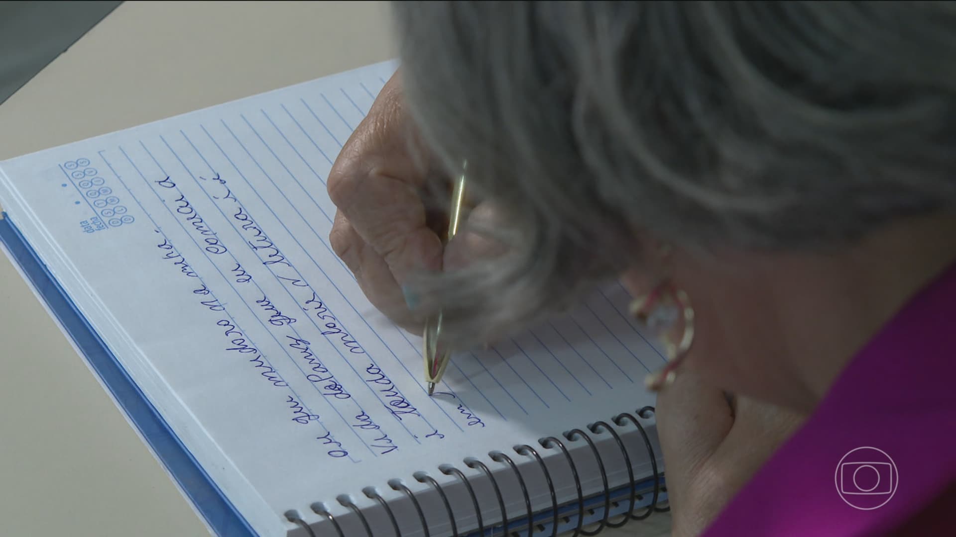Mulher idosa estuda caderno em sala de aula de alfabetização em Boa Vista.
