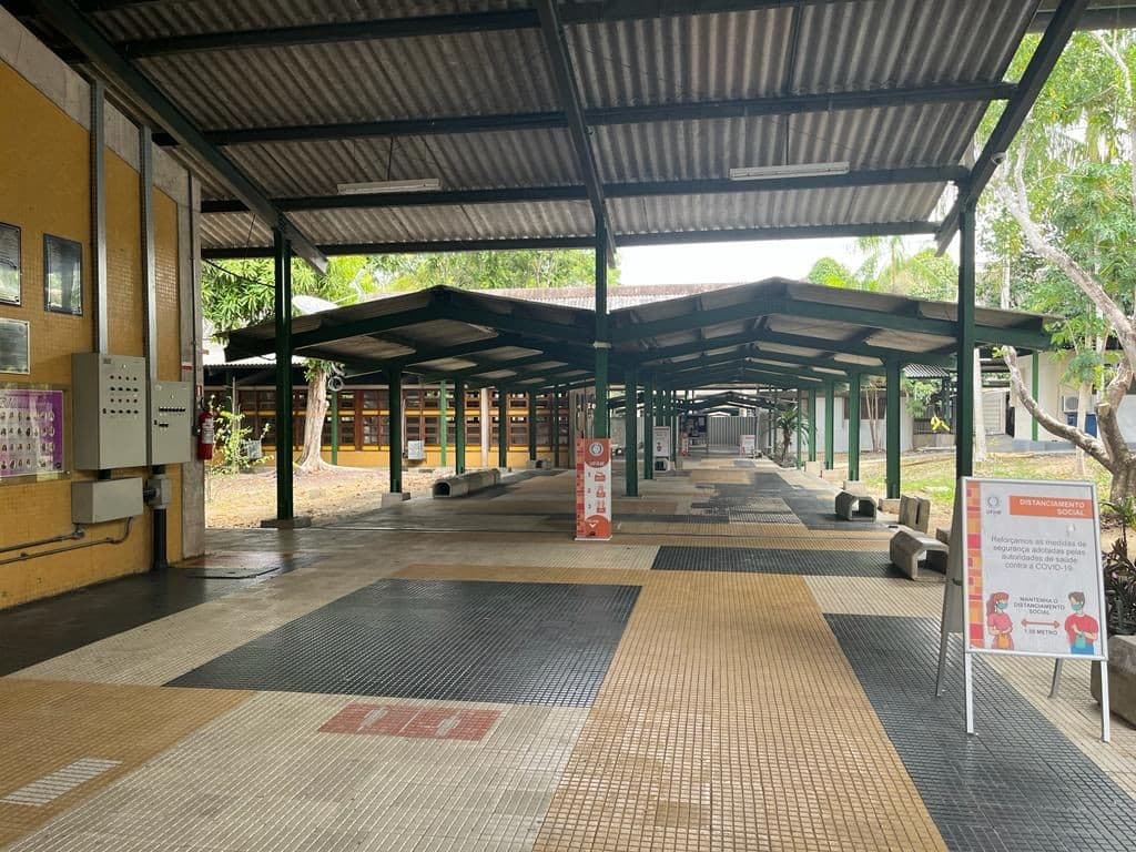 Estudantes organizam canetas e documentos sobre mesa antes de início de prova.
