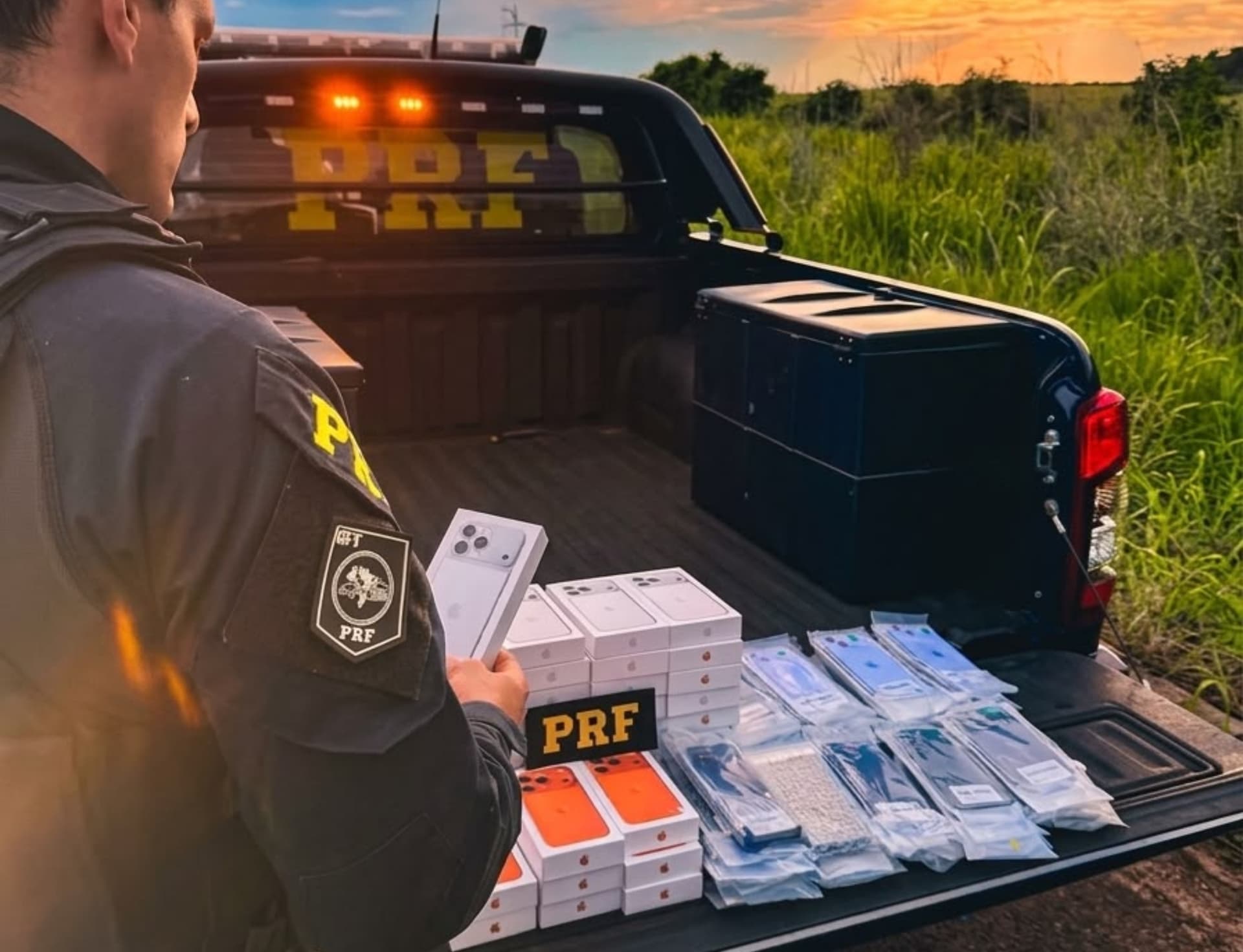 Policiais da PRF analisam caixas de aparelhos celulares apreendidos em fiscalização de rodovia em Roraima.