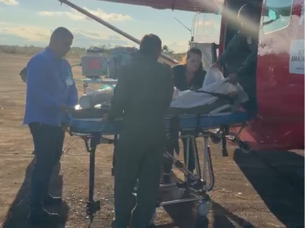Equipes do Corpo de Bombeiros retiram maca com criança de helicóptero em Porto Velho.