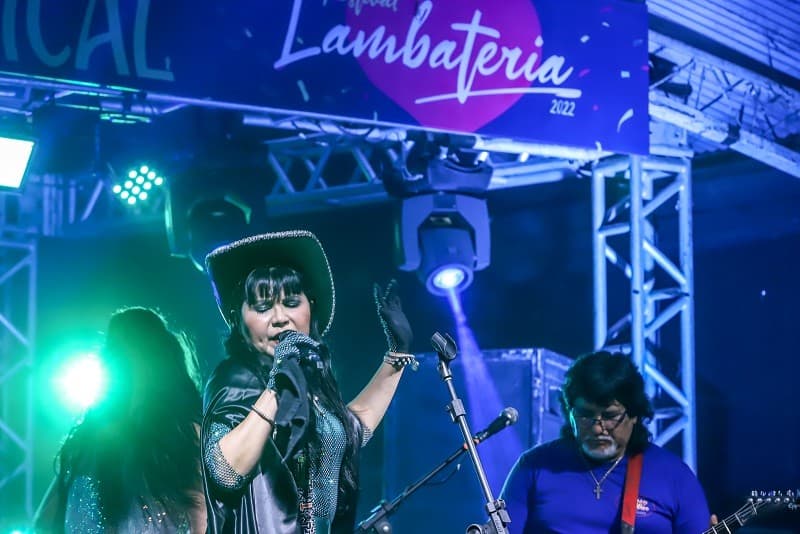 Palco iluminado com bandeiras coloridas durante show noturno de festival de música em Belém.