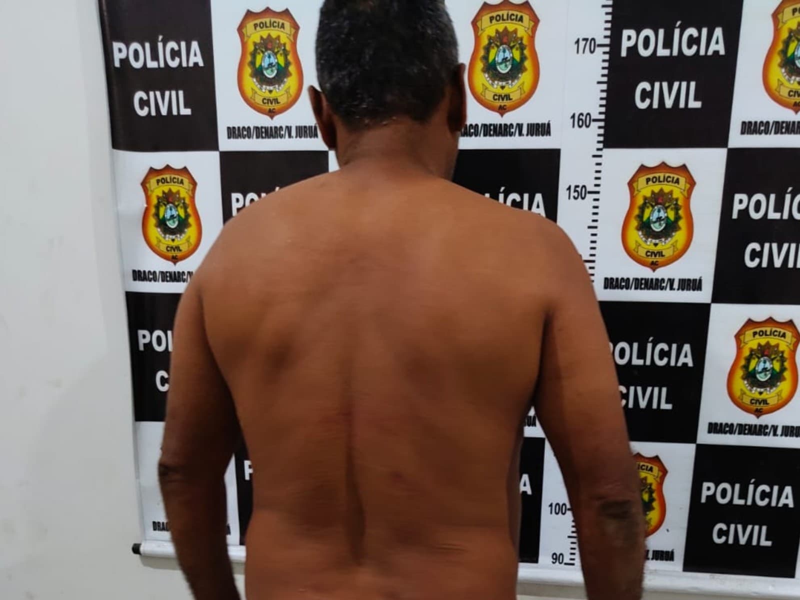 Viatura da Polícia Civil estacionada em rua residencial no interior do Acre.
