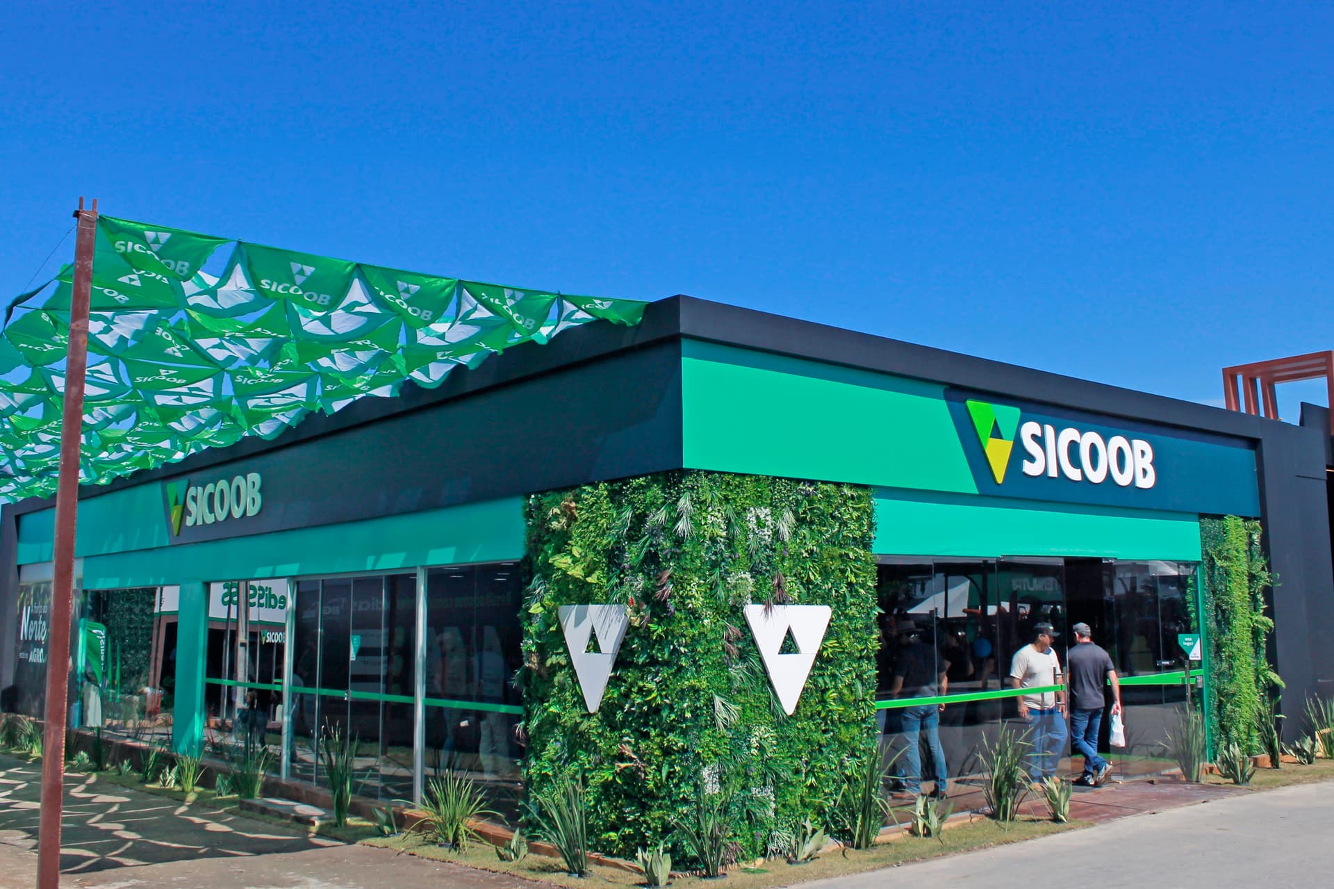 Estande do Sicoob com atendimento de produtores durante feira agropecuária em Vilhena.