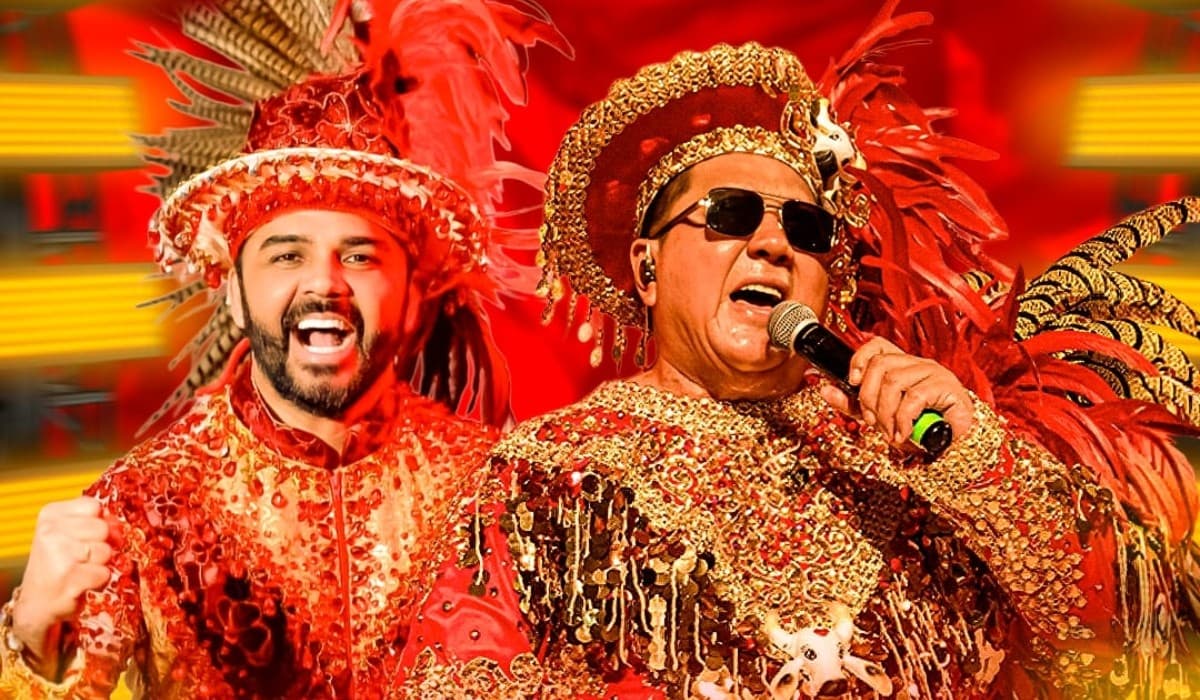 Apresentadores e torcida vestidos de branco e vermelho agitam arquibancada do Sambódromo em noite de ensaio.