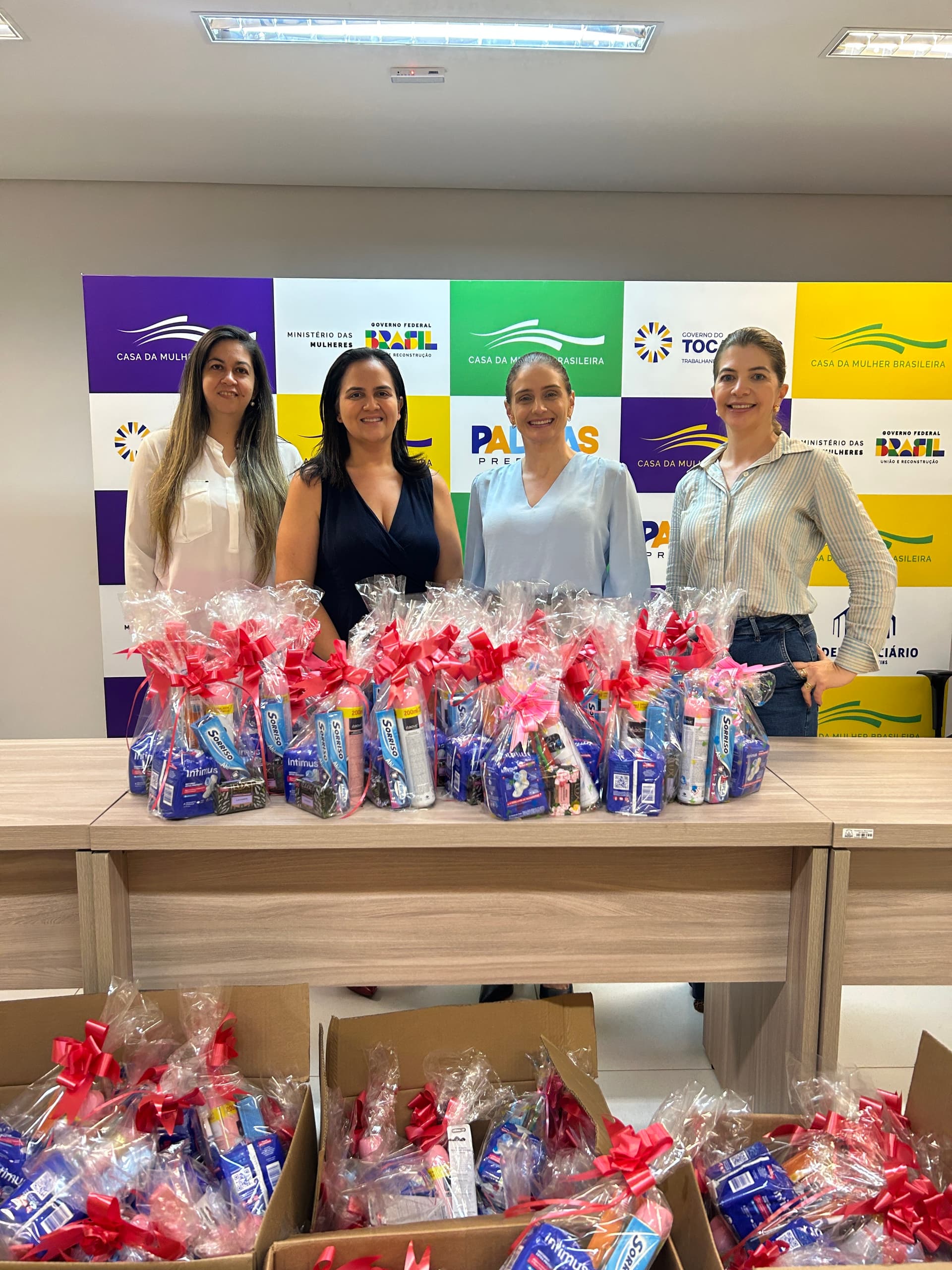 Pessoas organizam itens de leilão em galpão rural durante a preparação do evento beneficente em Palmas.