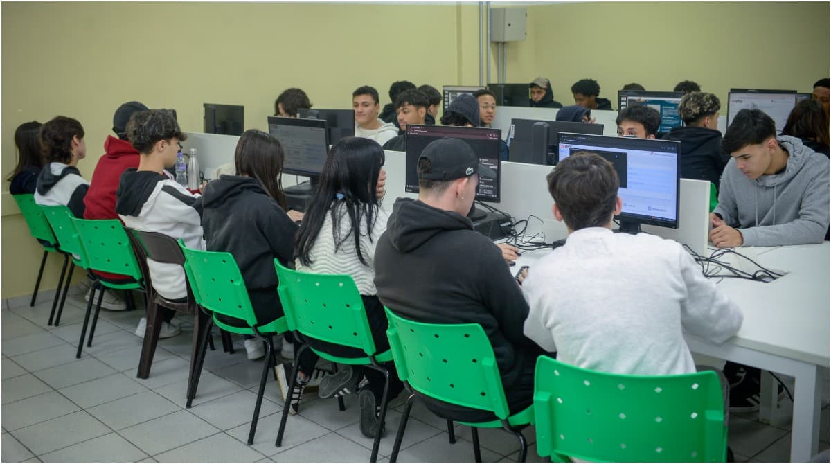 Estudantes sentados em sala com materiais de escritório.