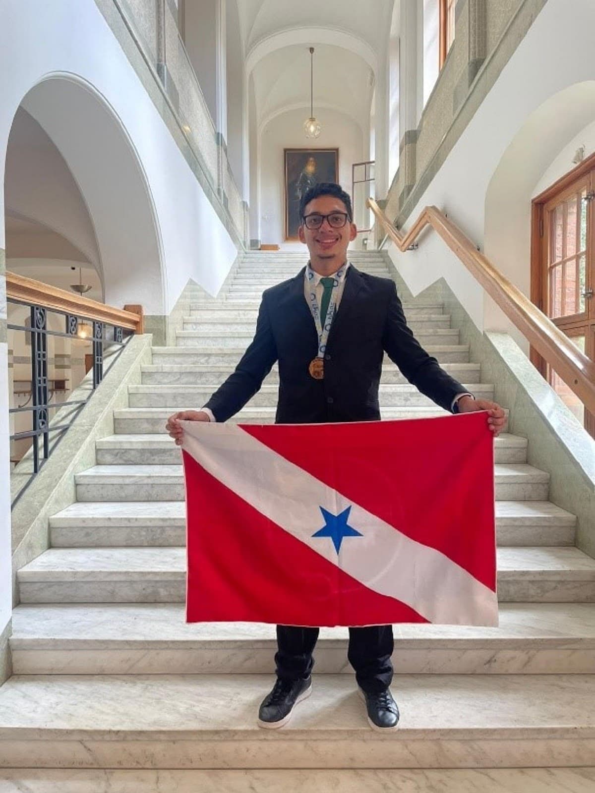 Estudante segura medalha de bronze sobre mesa de estudo em Ourilândia do Norte, no Pará.