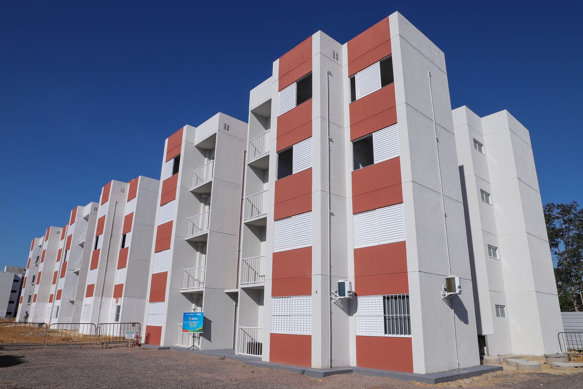 Frente de prédios do programa habitacional em dia ensolarada na periferia de Manaus.