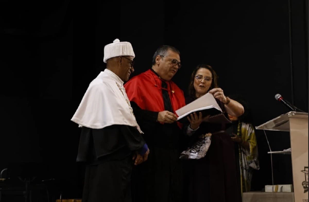 Ministro do STF segura diploma e dossiê histórico durante cerimônia no Centro de Eventos Benedito Nunes.