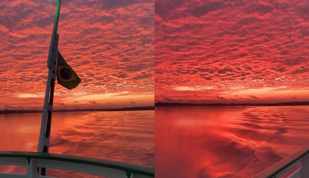 Céu em tons rosa e laranja refletido nas águas escuras do Rio Madeira ao amanhecer.