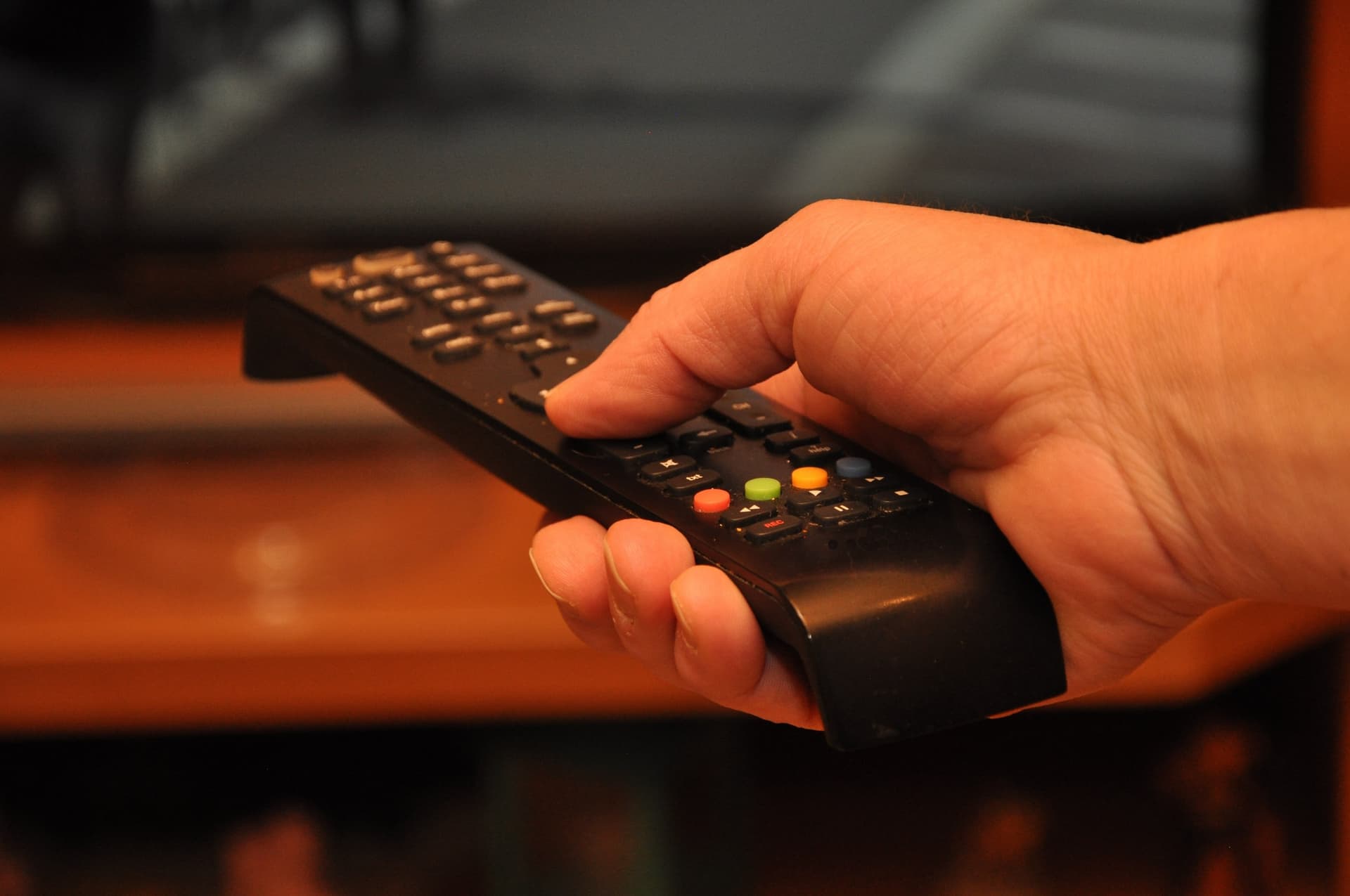 Mãos de uma mulher conectam cabo de antena digital na entrada de televisor em sala de estar em Macapá.