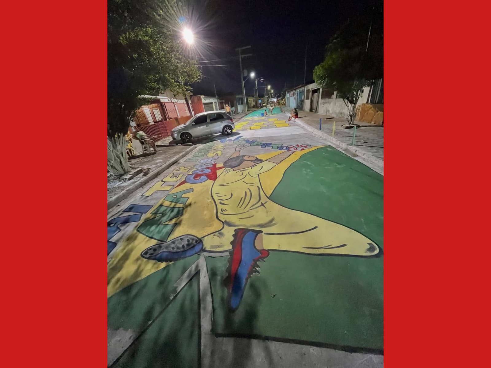 Moradores pintam asfalto de amarelo e verde em rua de Rio Branco durante a tarde.