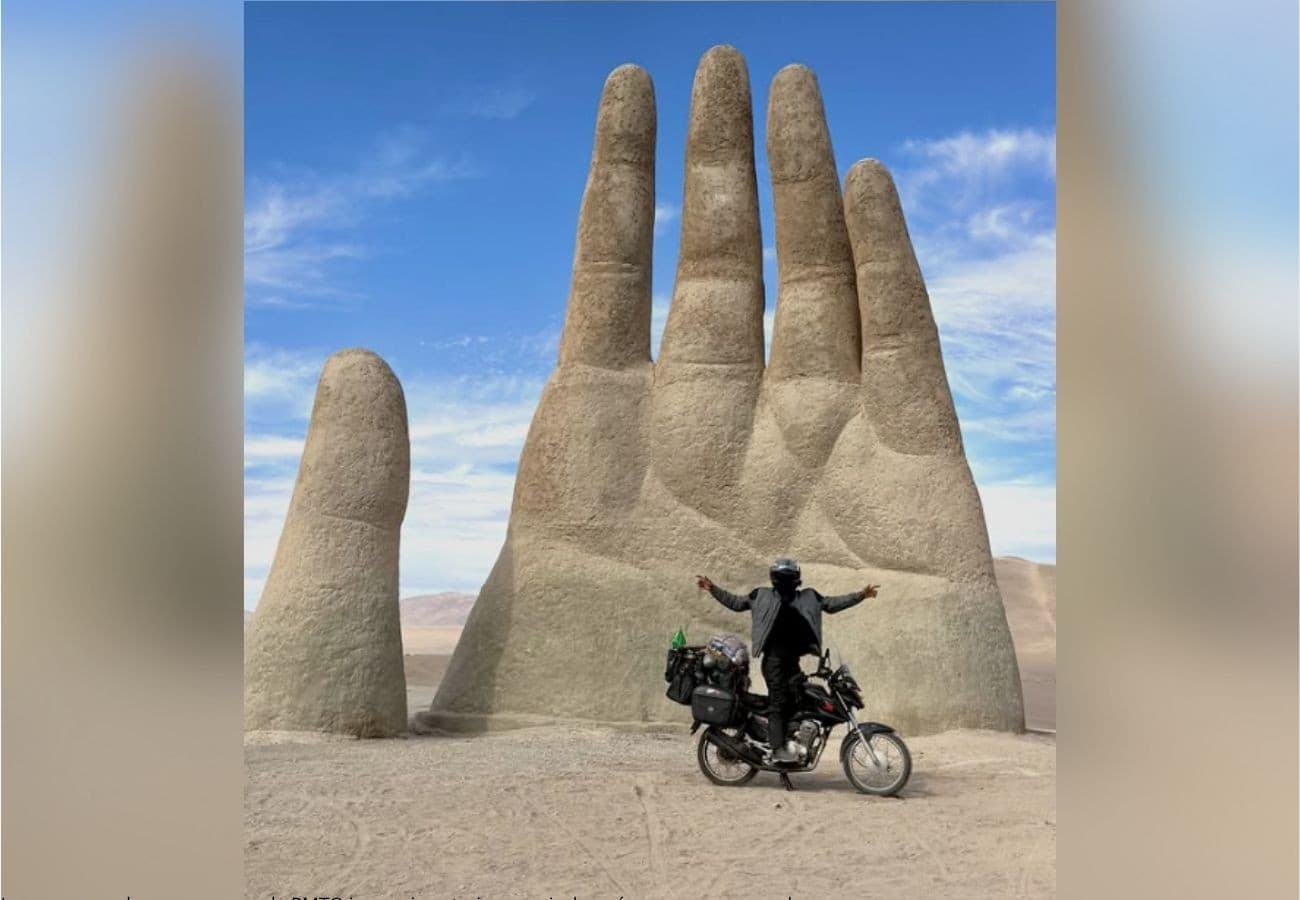 Moto estacionada em estrada coberta de neve no Chile com montanhas ao fundo.