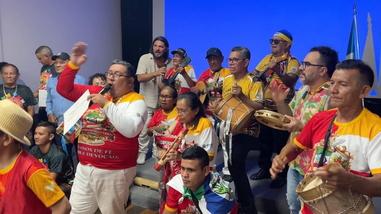 Mestre toca tambor de gambá durante cerimônia de registro de patrimônio em Manaus.
