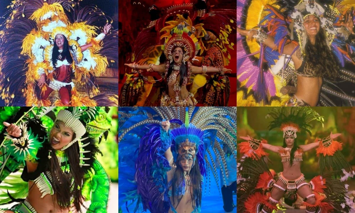 Cunhã-poranga dança no centro do Bumbódromo durante apresentação noturna, com traje indígena ornado com penas coloridas e colares de miçangas.