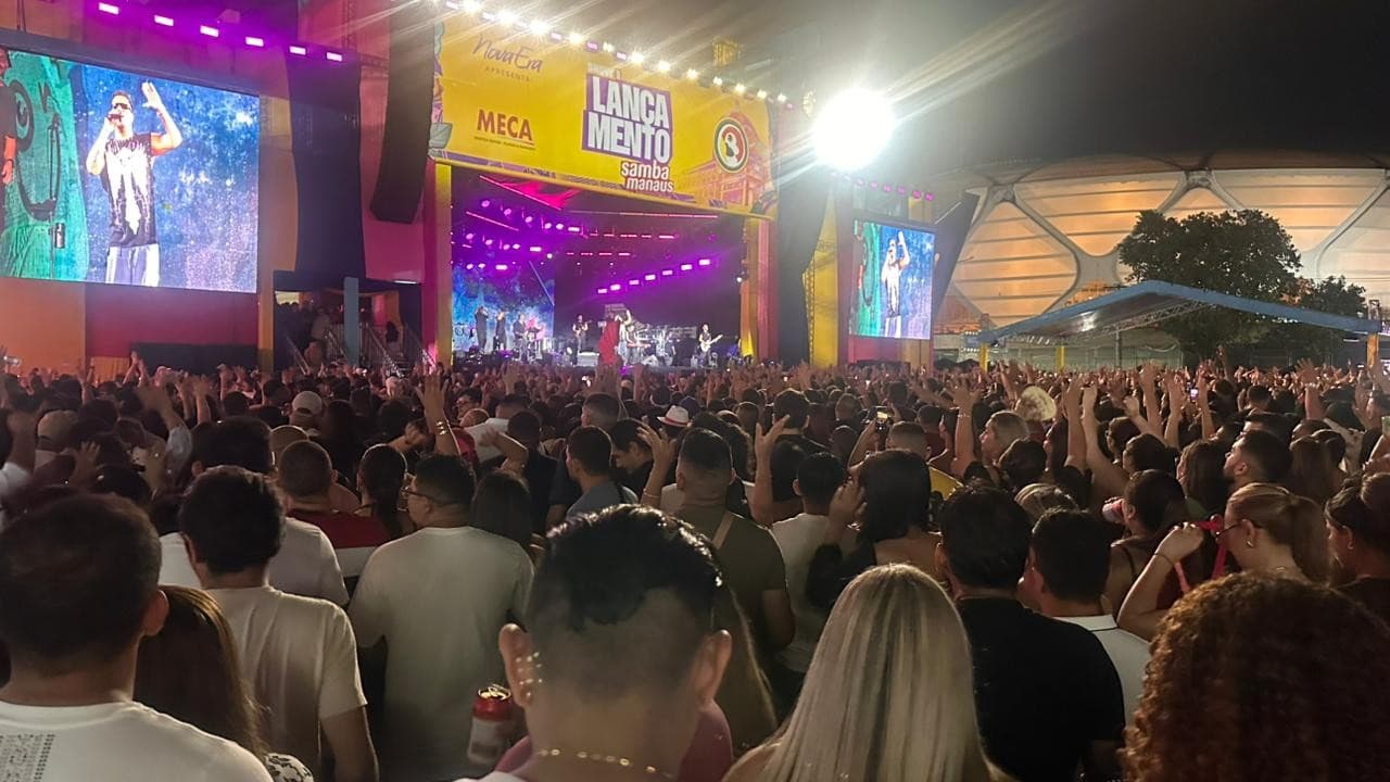 Palco iluminado do Sambódromo de Manaus durante noite de shows, com público em pé.