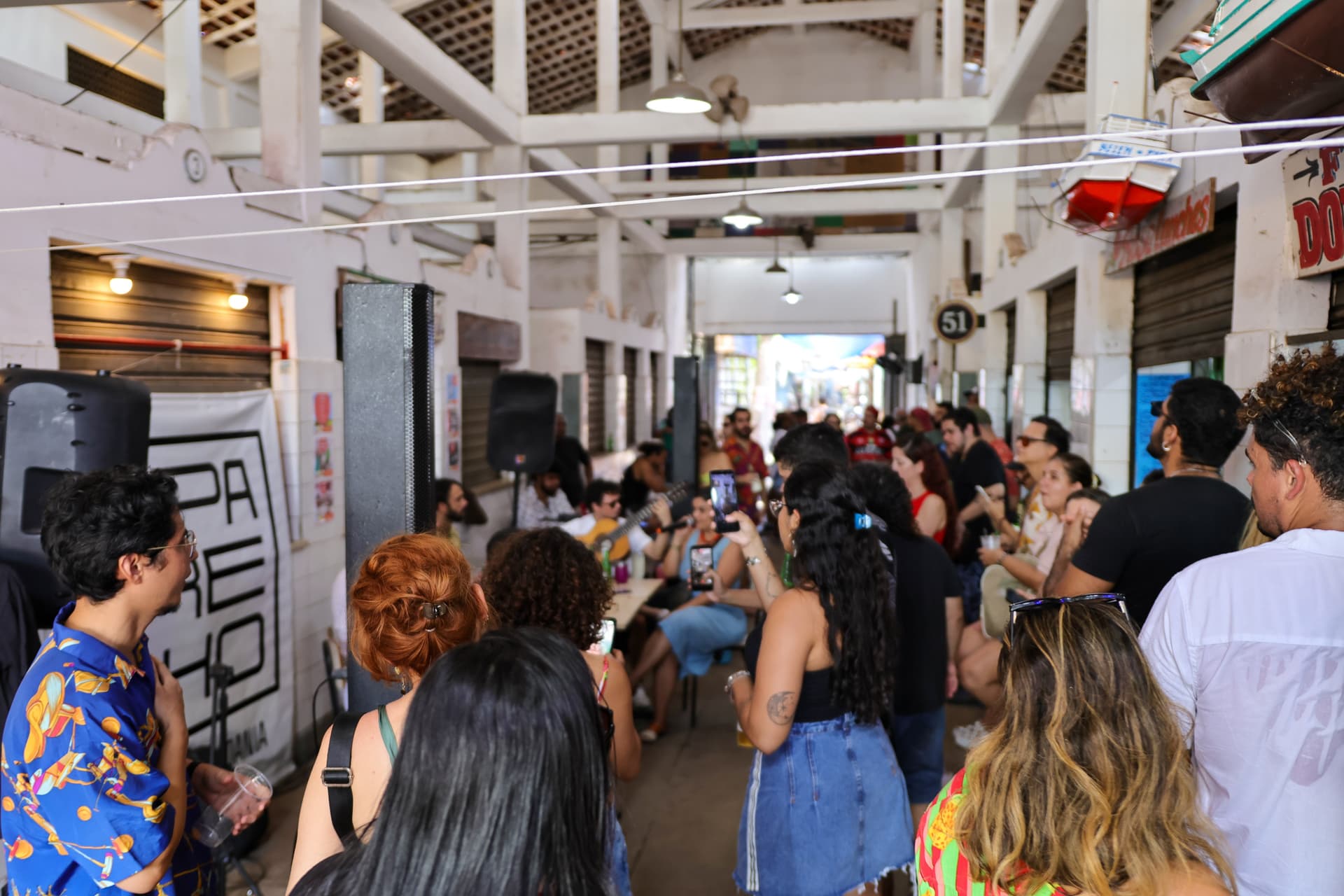 Pessoas caminham por rua calçada de bairro histórico em Belém durante evento cultural ao ar livre.