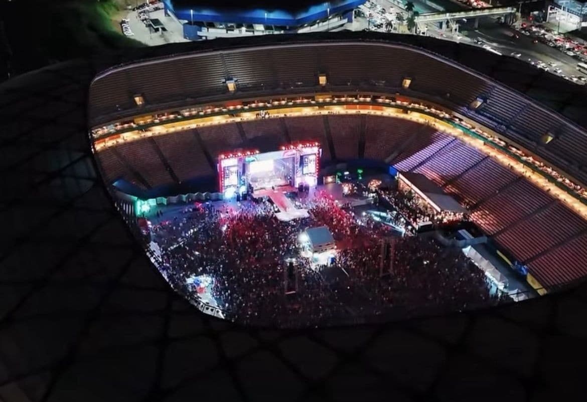 Palco iluminado com luzes azul e vermelha durante ensaio na Arena da Amazônia.