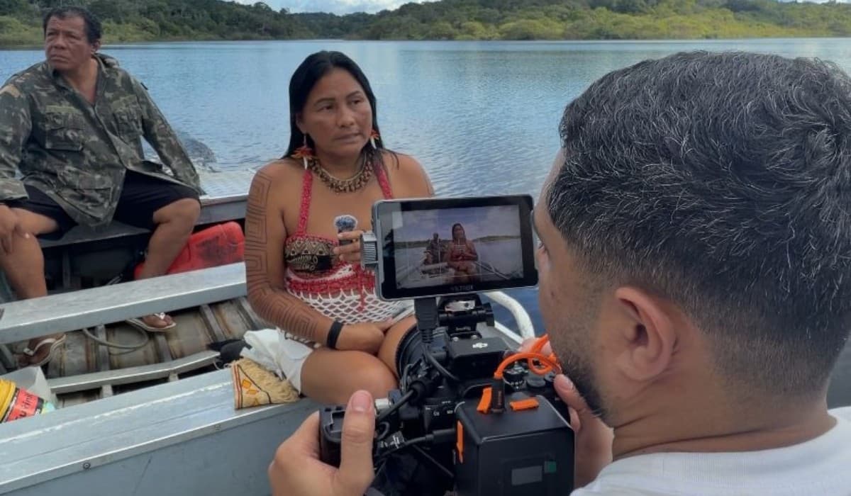 Jovem utiliza smartphone para gravar vídeo em rua de bairro periférico de Manaus.