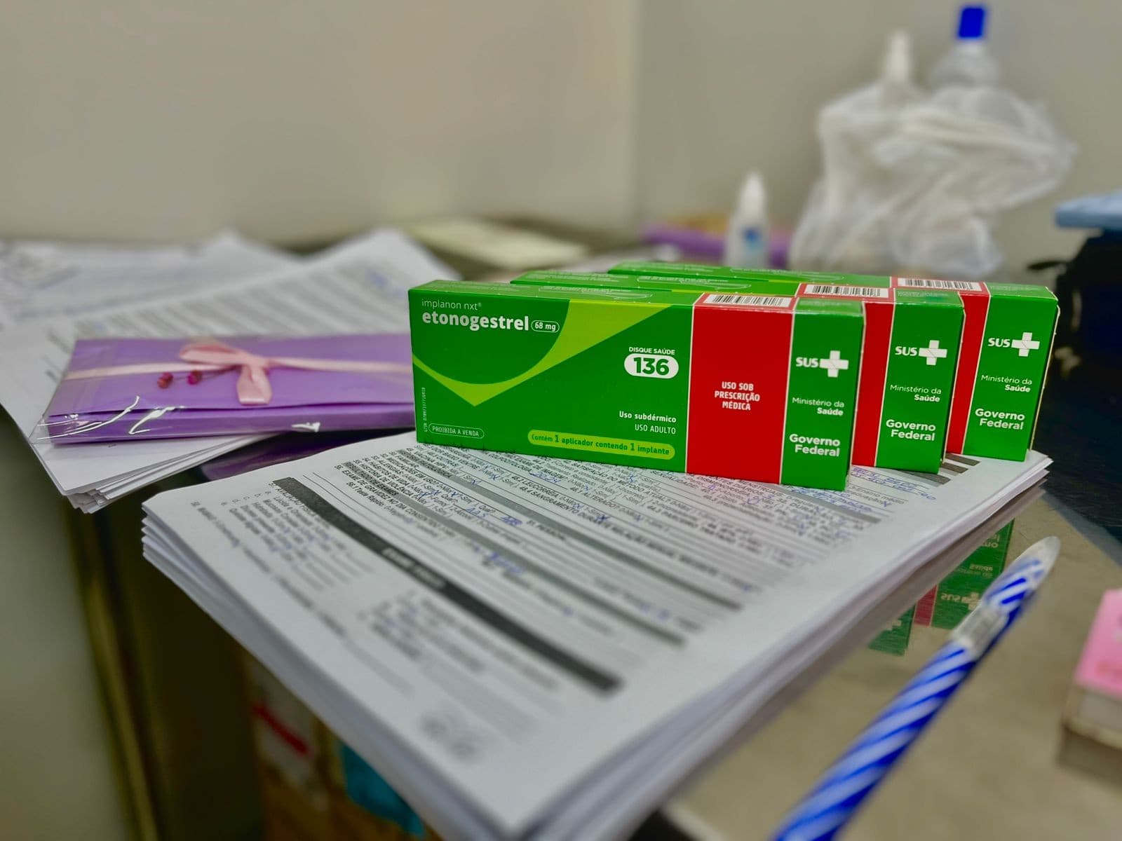 Braço de paciente durante procedimento de inserção de implante anticoncepcional em posto de saúde.