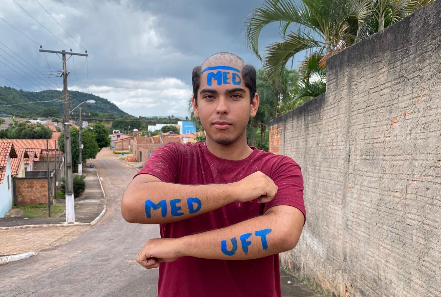 Jovem estudante sentado à mesa com livros de anatomia abertos.